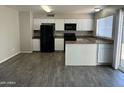Modern kitchen featuring white cabinets, black appliances, and sleek countertops for easy maintenance at 808 N 67Th Ln, Phoenix, AZ 85043