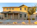Charming two-story home featuring a cozy front porch with desert landscaping and a tiled roof at 822 E Agua Fria Ln, Avondale, AZ 85323