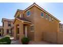 Two-story home with a covered entry and desert landscaping featuring warm earthy tones and architectural details at 917 E Agua Fria Ln, Avondale, AZ 85323