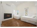Bright bedroom featuring hardwood floors, fireplace and natural light from two windows at 10152 E Phantom Way, Scottsdale, AZ 85255