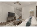 Inviting living room with comfortable white sofa, media console, and staircase, perfect for relaxing and entertaining at 10370 W Sands Dr # 463, Peoria, AZ 85383