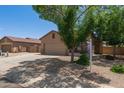 Single-story tan home featuring a two-car garage and manicured landscaping in a suburban neighborhood at 10735 E Kilarea Ave, Mesa, AZ 85209