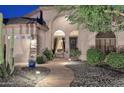 Stunning front entrance featuring well-lit walkway, desert landscape, and decorative stone accents at 1085 E Oakland Ct, Gilbert, AZ 85295