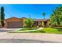 Charming brick home with a two-car garage, mature trees, and a well-manicured lawn at 125 E Loma Ln, Phoenix, AZ 85020