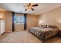Cozy primary bedroom with carpet flooring, a ceiling fan, and a large window with curtains at 1585 E Jeanne Ln, San Tan Valley, AZ 85140