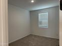 Cozy bedroom featuring neutral carpet, a bright window and fresh paint at 18240 W La Senda Dr, Surprise, AZ 85387