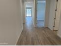 Well-lit hallway with wood-look tile flooring leading to the backyard, perfect for welcoming guests at 18240 W La Senda Dr, Surprise, AZ 85387
