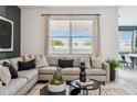 Comfortable living room with a gray sectional sofa, neutral decor, and bright natural light at 24079 W Cocopah St, Buckeye, AZ 85326