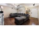 Cozy living room with hardwood floors, a large sectional couch, and natural light from a window at 255 N Hunt E Dr, Mesa, AZ 85203