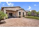 Private backyard features a brick patio, synthetic grass area, and mature landscaping at 2759 E Mews Rd, Gilbert, AZ 85298