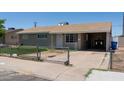 Single story home with neutral siding, brown roof, chain link fence, covered carport, and concrete driveway at 3802 W Mulberry Dr, Phoenix, AZ 85019