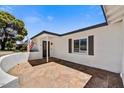 View of a stone-tiled front porch with an American flag, leading to a light-filled home at 4243 E Avalon Dr, Phoenix, AZ 85018