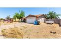 A single story home with a two car garage, long driveway and xeriscaped front yard at 4845 W Sweetwater Ave, Glendale, AZ 85304