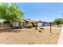 View of a charming single story home with a xeriscaped front yard and mature trees at 4845 W Sweetwater Ave, Glendale, AZ 85304