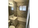 Updated bathroom with shower-tub combo, marble-look tile and updated vanity at 5735 N 32Nd Dr, Phoenix, AZ 85017