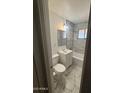 Clean, updated bathroom with marble-look tiles and classic white vanity at 5735 N 32Nd Dr, Phoenix, AZ 85017