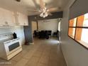 Bright eat-in kitchen with tile flooring and white appliances flows into the dining area at 5735 N 32Nd Dr, Phoenix, AZ 85017
