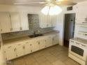 Traditional kitchen with white cabinetry, light countertops, and tile flooring at 5735 N 32Nd Dr, Phoenix, AZ 85017