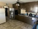 A functional kitchen featuring dark wood cabinets and stainless steel appliances and tile floors at 61 W 11Th Dr, Mesa, AZ 85210