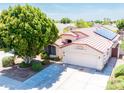 Features a well-manicured lawn, a home with a two-car garage, and solar panels on the roof at 6415 W Escuda Rd, Glendale, AZ 85308