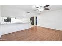 This open-concept space features a breakfast bar, light walls, and dark wood vinyl flooring at 9641 N 36Th Dr, Phoenix, AZ 85051