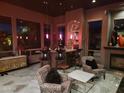Stylish living room with a full bar, elegant decor, fireplace, and comfortable seating area at 11320 E Winchcomb Dr, Scottsdale, AZ 85255