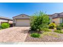 Single-story home with a two-car garage and brick paver driveway, surrounded by landscaped desert plants and blue skies at 12204 W Parkway Ln, Avondale, AZ 85323