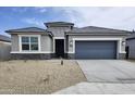 Inviting single-story home with a grey exterior, desert landscaping, and a two-car garage at 1648 S 241St Ave, Buckeye, AZ 85326