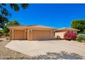 Single-story home with a three-car garage, desert landscaping, and a sunny blue sky above at 16972 W Anasazi Ct, Surprise, AZ 85387