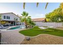 Lush backyard featuring a sparkling pool, artificial grass, hammock, and lounge chairs perfect for outdoor relaxation at 1723 E Pontiac Dr, Phoenix, AZ 85024