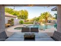 Inviting backyard oasis featuring a sparkling pool, spa, rock waterfall, and outdoor seating area, perfect for entertaining at 1723 E Pontiac Dr, Phoenix, AZ 85024