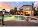 Beautiful backyard at twilight featuring a pool, spa, patio seating, and string lights, creating an inviting outdoor space at 1723 E Pontiac Dr, Phoenix, AZ 85024