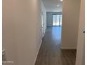Hallway view with wood-look tile leading towards the bright living area and sliding glass door at 18232 W La Senda Dr, Surprise, AZ 85387