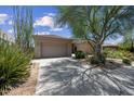 A wide driveway leads to a two-car garage, complemented by desert landscaping at 33317 N 71St St, Scottsdale, AZ 85266