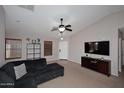 Bright living room with a modern ceiling fan, neutral walls, and ample natural light at 42382 W Hillman Dr, Maricopa, AZ 85138