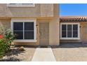 Beige townhouse facade with desert landscaping with cactus, shrubs, and sidewalk at 4601 N 102Nd Ave # 1055, Phoenix, AZ 85037