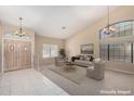 Bright living room with high ceilings, natural light, neutral paint, tile entry, and carpet at 5517 W Aster Dr, Glendale, AZ 85304