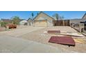 Spacious driveway leading to a two-car garage, complemented by desert landscaping at 6804 W Turquoise Ave, Peoria, AZ 85345