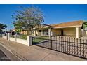 Charming single-story home with a well-maintained front yard and decorative brick and iron fence at 1045 S Solomon St, Mesa, AZ 85204