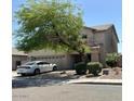 Home with two-car garage and desert landscaping featuring mature trees and bushes for low maintenance at 11633 W Jefferson St, Avondale, AZ 85323