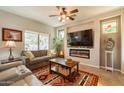 Cozy living room features a modern fireplace, ceiling fan and patio access at 1552 E Manor Dr, Casa Grande, AZ 85122