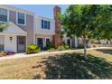 Townhome exterior with brick chimney and mature tree, offering shaded comfort and character at 1600 N Saba St # 151, Chandler, AZ 85225