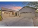 Spacious driveway leading to a three-car garage, with well-maintained desert landscaping around the property at 18199 W Buckhorn Dr, Goodyear, AZ 85338