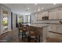 Open kitchen featuring an island with bar seating, stylish pendant lights, and modern appliances at 18837 W San Juan Ave, Litchfield Park, AZ 85340