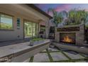 Outdoor patio featuring a stone fireplace, built-in grill, and a seamless transition to indoor spaces at 199 E Tangerine Path, Queen Creek, AZ 85140