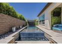 Long, narrow pool boasts integrated water features and a modern pergola with stylish landscaping at 199 E Tangerine Path, Queen Creek, AZ 85140