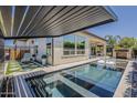 Backyard showcasing a pool with a pergola, an outdoor fireplace, and stylish patio seating at 199 E Tangerine Path, Queen Creek, AZ 85140