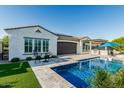 Spacious backyard featuring a pool, barstool seating, and outdoor kitchen, perfect for entertaining at 20595 W Pasadena Ave, Buckeye, AZ 85396