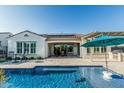 Relaxing backyard featuring a pool, covered patio, and beautiful landscaping at 20595 W Pasadena Ave, Buckeye, AZ 85396