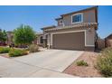 Charming two-story home features a well-manicured lawn, desert landscaping, and a spacious two car garage at 25546 N 164Th Dr, Surprise, AZ 85387